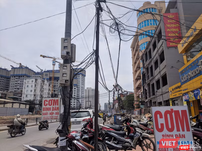 Dây điện, cáp viễn thông bó thành búi trước các cửa hàng.