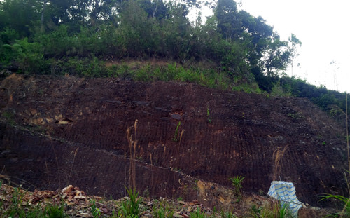 Ngọn núi nơi đường hầm thông qua. Miệng hầm được che kín bạt trắng. Ảnh: Tiến Hùng.