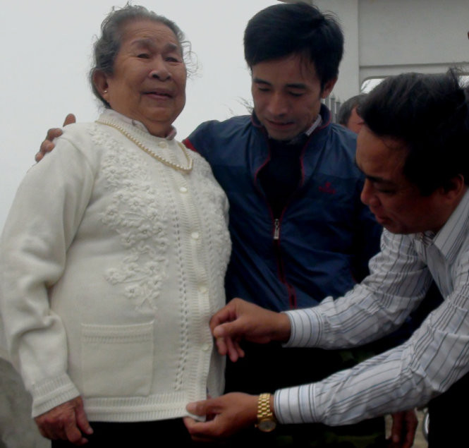 Đồng đội của liệt sĩ Phương đều gọi bà Hồ Thị Đức, mẹ liệt sĩ Phương, là mẹ. Trong ảnh: Một cựu binh Gạc Ma sửa lại vạt áo cho mẹ Đức - Ảnh: Quốc Nam