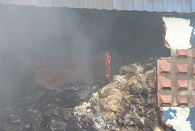 Lửa vẫn cháy âm ỉ trong kho hóa chất - Ảnh: Xuân An