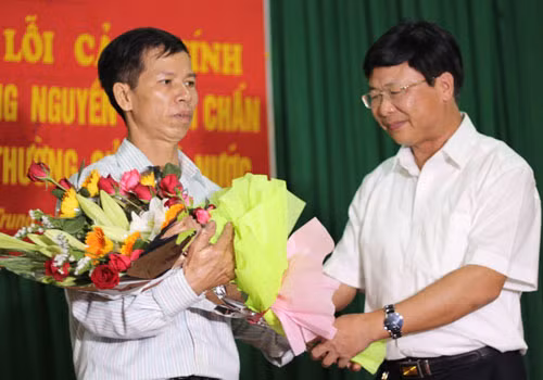 Phó Chánh toà phúc thẩm TAND Tối cao Ngô Hồng Phúc tặng hoa ông Nguyễn Thanh Chấn sau khi đọc bản xin lỗi.