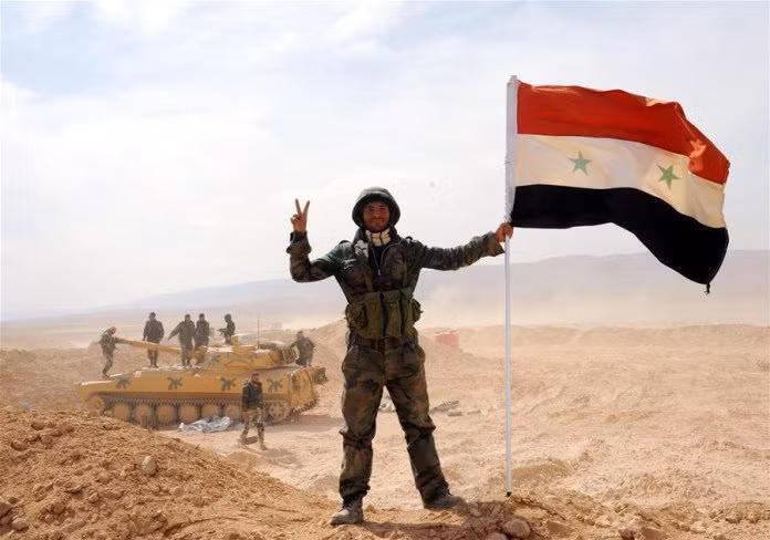 Binh sĩ Syria cùng lá cờ trên sa mạc Palmyra (ảnh minh họa)