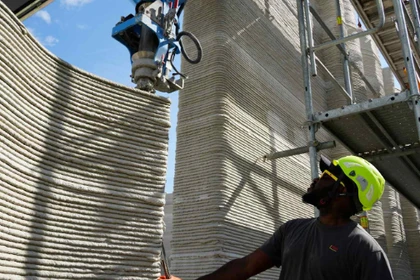 Một cánh tay robot thuộc hệ thống sản xuất bồi đắp đang xếp chồng các lớp bê tông để xây dựng tòa nhà in 3D lớn nhất châu Âu tại Heidelberg, Đức. Ảnh: Nikkei Asia.