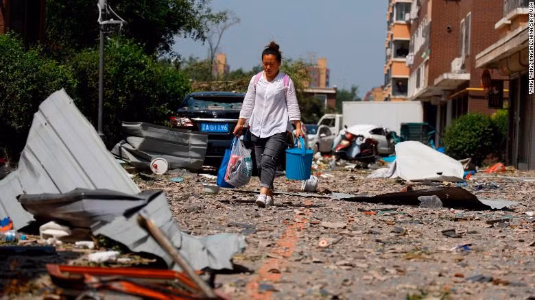 Một người dân đi qua đống hoang tàn sau trận lốc xoáy (Ảnh: CNN)