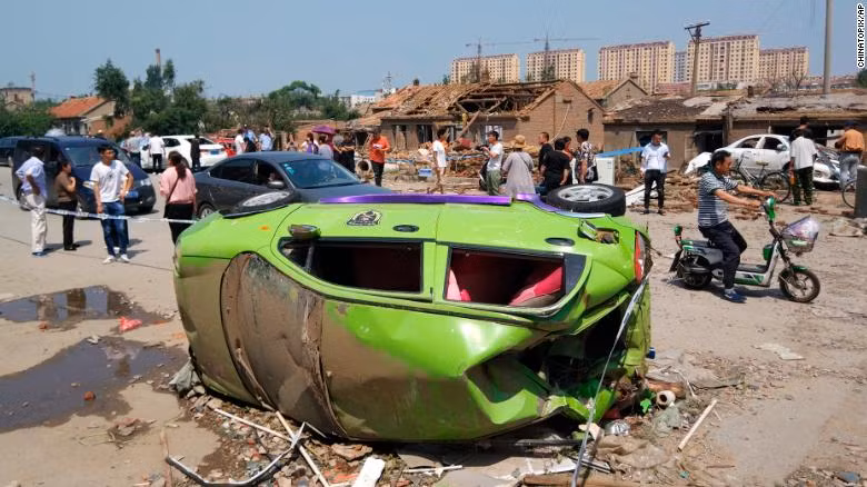 Một chiếc xe hơi bị quật đổ do lốc xoáy (Ảnh: CNN)