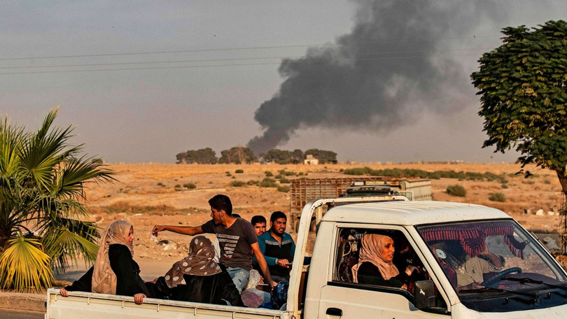Người dân tháo chạy trong lúc cột khói lớn bốc lên từ thị trấn Ras al-Ain, Đông Bắc Syria sau đòn không kích của Thổ Nhĩ Kỳ (Ảnh: ABC)