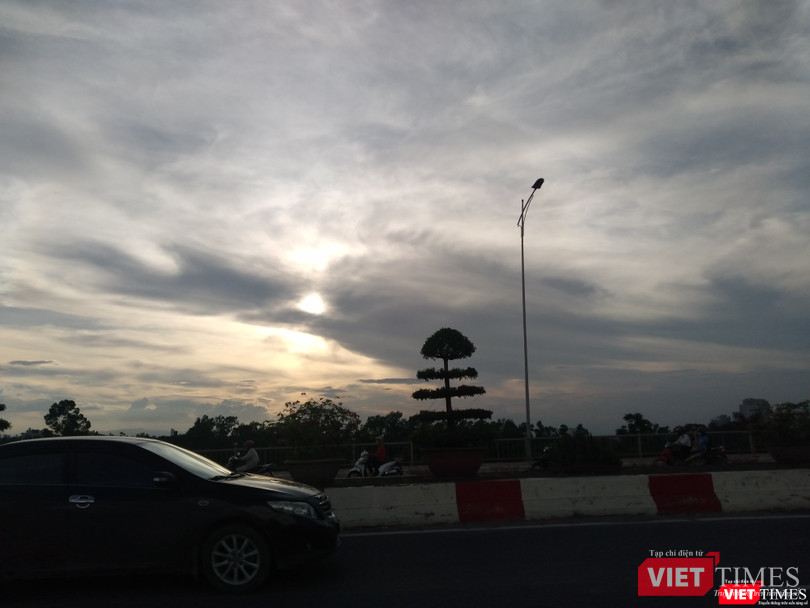 Cặp cá làm duyên trong ánh chiều hoàng hôn với mặt trời ở giữa.