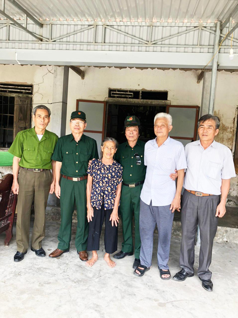 Bà Cao Thị Bối - người chị dâu hiện đang chăm sóc hương khói cho Anh hùng liệt sĩ Hoàng Mai Vượng - cùng với cựu binh 631 trước ngôi nhà của bà