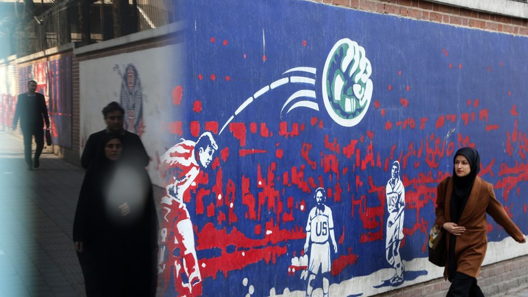 Người dân đi ngang qua những bức tranh tường có nội dung phản đối Mỹ ở Tehran, Iran. Ảnh: Getty.