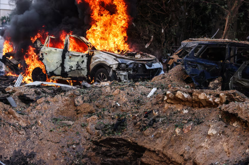 Một chiếc xe hơi bốc cháy tại hiện trường sau các đợt tấn công tên lửa của Iran ở Tel Aviv, Israel ngày 24/3. Ảnh: Reuters.