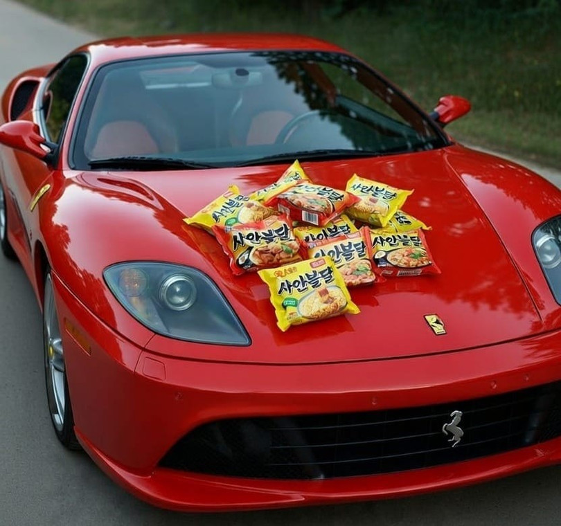 Những gói mì có giá phải chăng được đặt trên một chiếc Ferrari trong bức ảnh "thử thách nghèo đói" ở Hàn Quốc. Ảnh: OC.