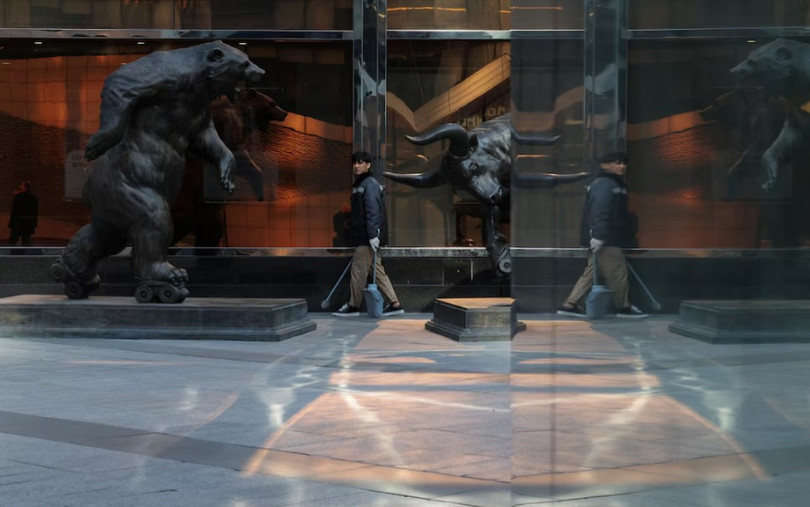 Một người quét dọn đi bộ gần các tác phẩm điêu khắc dưới chân các tòa nhà chọc trời của Trung tâm Thương mại Quốc tế Moscow ngày 2/10. Ảnh: Reuters.