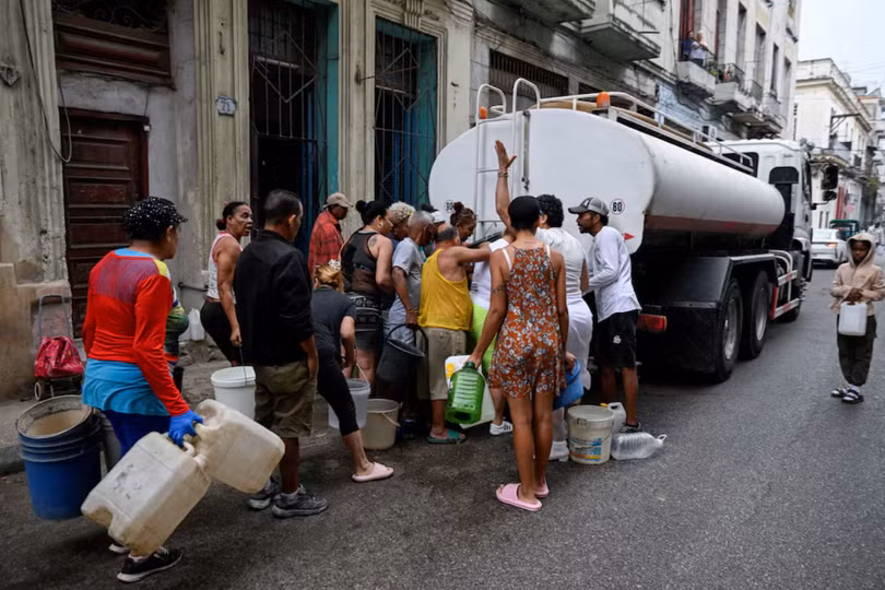 Người dân tập trung quanh một xe bồn chở nước để múc nước vào xô và các vật chứa khác do tình trạng thiếu nhiên liệu nghiêm trọng đã làm gián đoạn việc bơm và phân phối nước, tại Havana, Cuba ngày 19/3. Ảnh: Reuters.