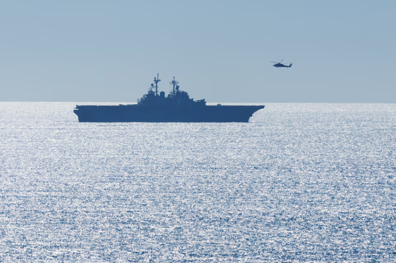 Một chiếc trực thăng bay ngang qua tàu USS Boxer (LHD 4), một tàu tấn công đổ bộ lớp Wasp, khi nó đang tham gia huấn luyện ngoài khơi bờ biển California gần Trại Pendleton, California, Mỹ ngày 16/10/2025. Ảnh: Reuters.