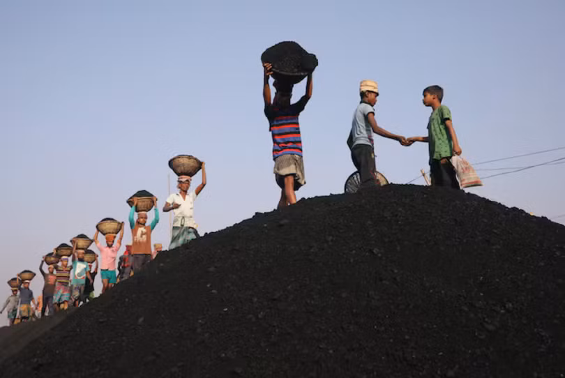 Hình ảnh các công nhân khai thác than đang dỡ hàng từ một chiếc phà tại một khu chợ ở Dhaka, Bangladesh ngày 13/1/2019. Ảnh: Reuters.