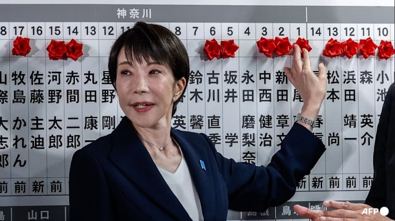 Thủ tướng Nhật Bản kiêm Chủ tịch Đảng Dân chủ Tự do (LDP) Sanae Takaichi đặt một bông hồng giấy màu đỏ lên tên của một ứng cử viên trúng cử tại trụ sở LDP trong cuộc bầu cử Hạ viện ở Tokyo ngày 8/2. Ảnh: AFP.