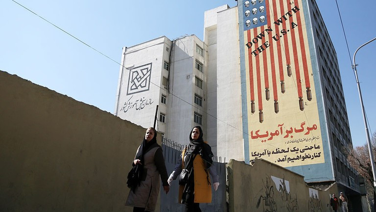 Hai phụ nữ đi qua một biểu ngữ nội dung chống Mỹ ở Tehran, Iran. Ảnh: Getty.