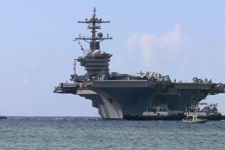 Các tàu kéo cảng dẫn đường cho tàu sân bay lớp Nimitz USS Abraham Lincoln khi tàu tiến vào Căn cứ Hải quân Mỹ ở Guam để thực hiện chuyến thăm cảng theo lịch trình, ngày 11/12/2025. Ảnh: Getty.