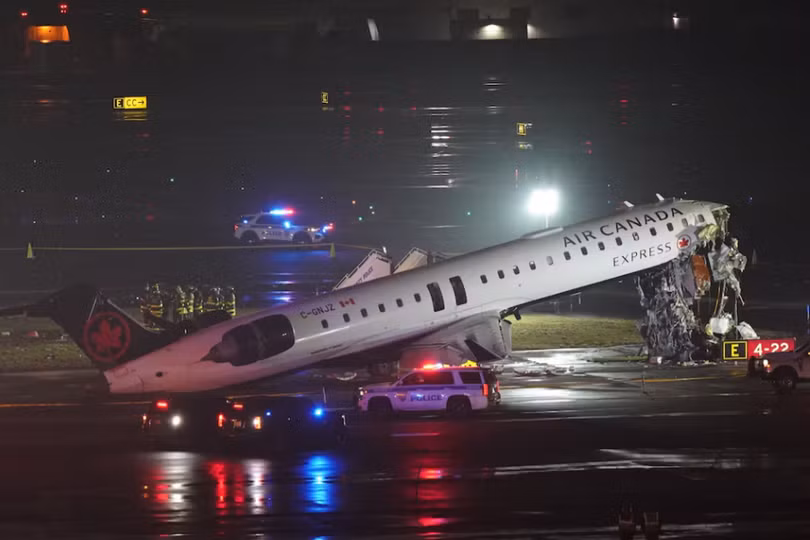 Các đội cứu hộ đang làm việc xung quanh chiếc máy bay Air Canada Express sau va chạm với một phương tiện trên mặt đất tại sân bay LaGuardia ở Queens, New York, Mỹ ngày 23/3. Ảnh: Reuters.
