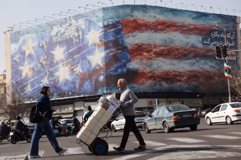 Người dân đi ngang qua một bảng quảng cáo chống Mỹ ở Tehran, Iran ngày 19/2. Ảnh: Reuters.