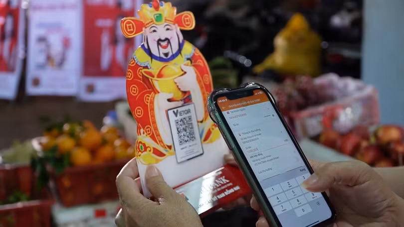 Tấm mã QR nhỏ bên sạp hàng cho thấy thanh toán số trở thành điều bình thường trong đời sống hằng ngày của người dân.