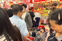 Vị khách nhí nằm chơi điện thoại trong lúc chờ bố mẹ mua hàng, hình ảnh quen thuộc trong những dịp Tết.