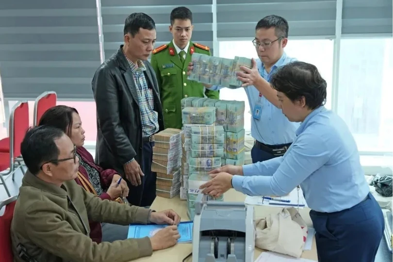 Người dân được nhân viên ngân hàng hỗ trợ nhận tiền bồi thường, hỗ trợ, tái định cư do phải di dời để thực hiện dự án làm quảng trường, công viên phía Đông hồ Hoàn Kiếm. Ảnh: Trọng Phú