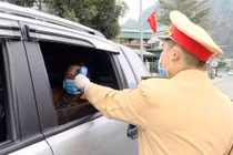 Công an TP Cẩm Phả vừa điều tiết giao thông vừa kết hợp với đo nhiệt độ người tham gia giao thông. Ảnh: UBND tỉnh Quảng Ninh.
