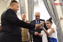 Imam Ali, bé gái 9 tuổi, được trao thư và quà của Tổng thống Putin tại Đại sứ quán Nga ở Syria (Ảnh: SANA)