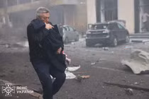 Một người đàn ông đưa đứa trẻ ra khỏi hiện trường một vụ tấn công tại Kharkov, Ukraine ngày 22/10. Ảnh: Reuters.