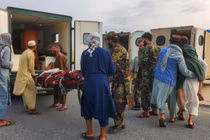 Binh lính Taliban và thường dân đưa nạn nhân động đất lên xe cứu thương tại sân bay ở Jalalabad, Afghanistan ngày 1/9. Ảnh: Reuters.