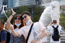 Du khách chụp ảnh tại công viên Merlion, Singapore (Ảnh: SCMP)