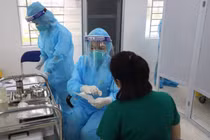 Nữ điều dưỡng Vũ Thị Thanh Thư trò chuyện với cán bộ tiêm chủng trước khi tiêm vaccine phòng COVID-19 (Ảnh: Đặng Thanh) 