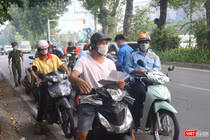 Người dân xếp hàng chờ kiểm tra giấy đi đường (Ảnh - Minh Thuý) 