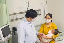 Bộ trưởng Bộ Y tế Nguyễn Thanh Long thăm em bé sau khi tiêm vaccine COVID-19 nhầm tại Trạm Y tế xã Yên Sơn, huyện Quốc Oai (Ảnh - Mạnh Cường) 