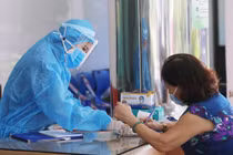 Nhân viên y tế hướng dẫn người dân khai báo y tế (Ảnh - BYT) 