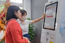 Nhân viên Bệnh viện Đà Nẵng hướng dẫn người bệnh sử dụng Ki-ốt y tế thông minh