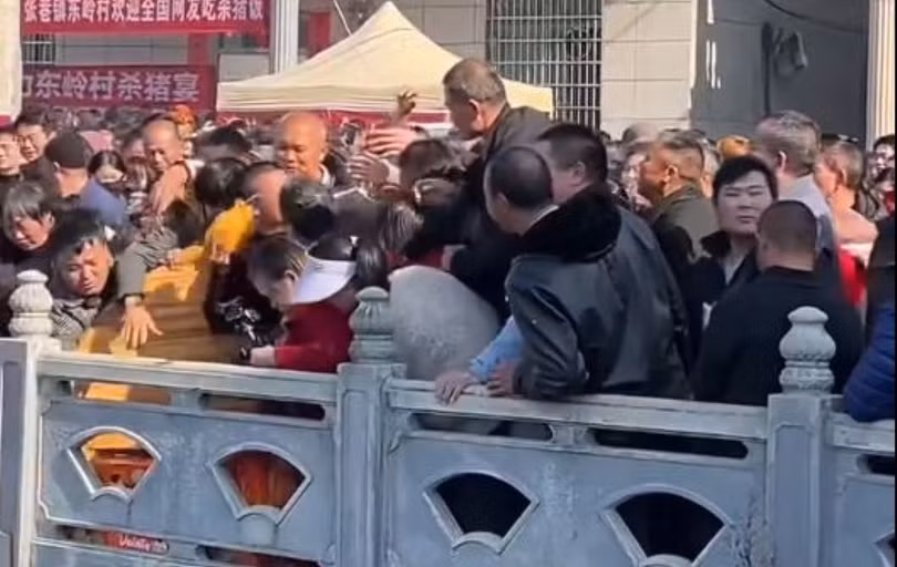 Cảnh tranh giành thức ăn hỗn loạn tại sự kiện "Sát trư yến". Ảnh: Singtao.