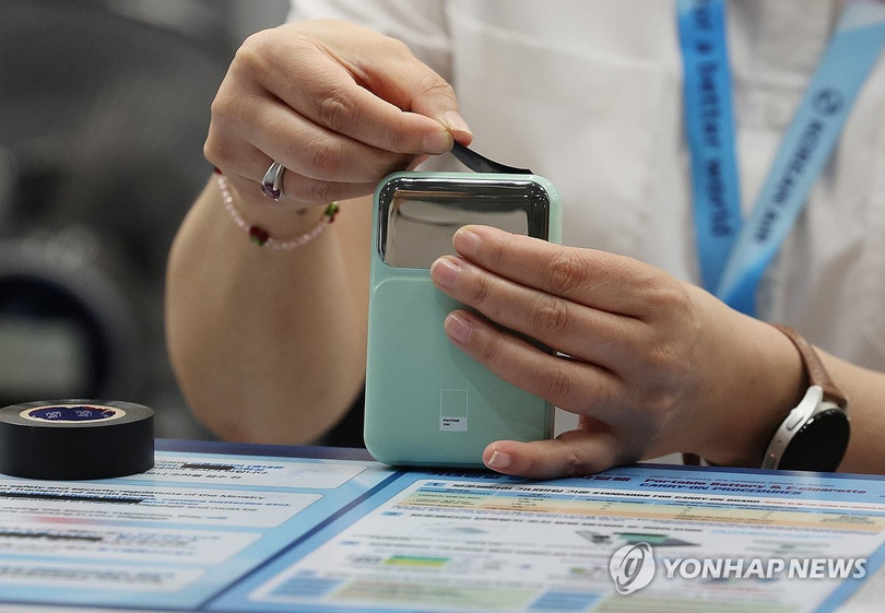 Nếu mang pin sạc lên máy bay phải dùng băng keo cách điện dán kín cổng ra. Ảnh: Yonhapnews.