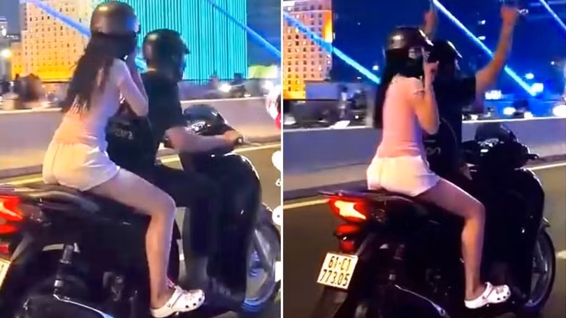 Nam thanh niên điều khiển xe máy SH chở theo người phía sau nhưng có hành vi buông hai tay để "biểu diễn" gây nguy hiểm cho người đi đường. Ảnh: Cắt từ clip.