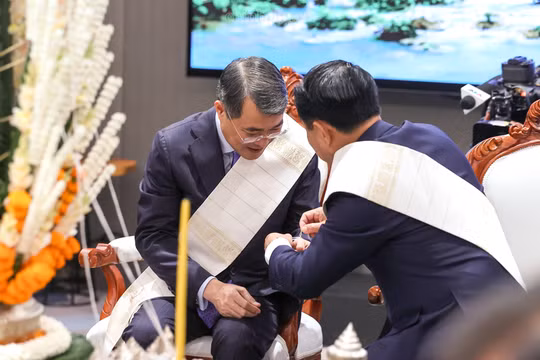 Thủ tướng Chính phủ Lào Saleumxay Kommasith buộc chỉ cổ tay cho Thủ tướng Chính phủ Lê Minh Hưng - Ảnh: chinhphu.vn/Nhật Bắc.