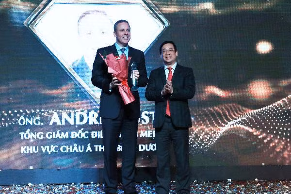 Ông Andre Musto -Tổng Giám đốc điều hành Merck khu vực châu Á Thái Bình Dương nhận hoa chúc mừng từ 