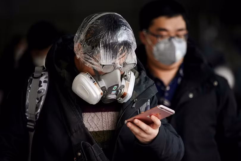 Một hành khách đeo khẩu trang, đội mũ che tóc dùng khi tắm và bịt mắt bằng cách này. Có thể thấy có rất nhiều hơi nước trong phần mặt nạ. (Ảnh: Reuters)