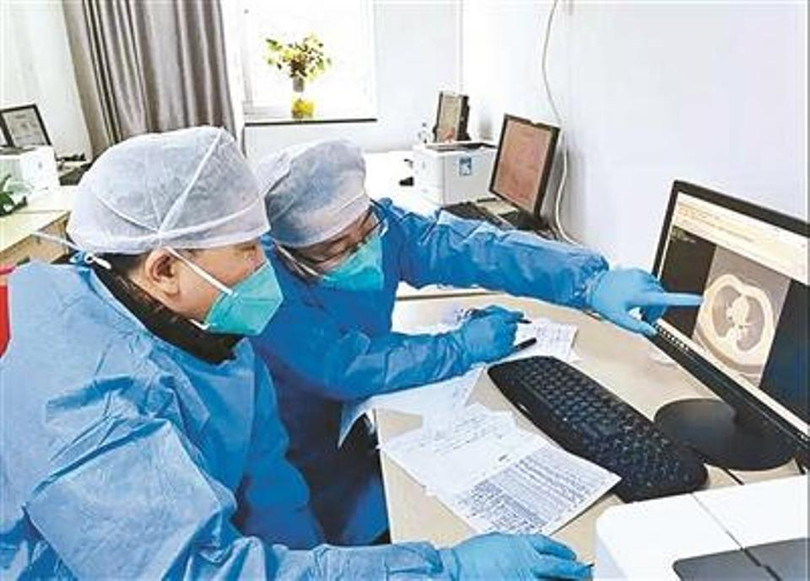 Ông Đồng Triều Huy (phải) hội chẩn với đồng nghiệp (Ảnh: Toutiao)