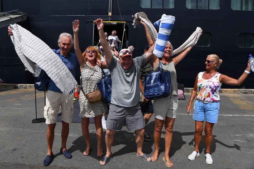 Hành khách vui mừng khi được lên bờ sau hàng chục ngày lênh đênh trên biển (Ảnh: AFP)