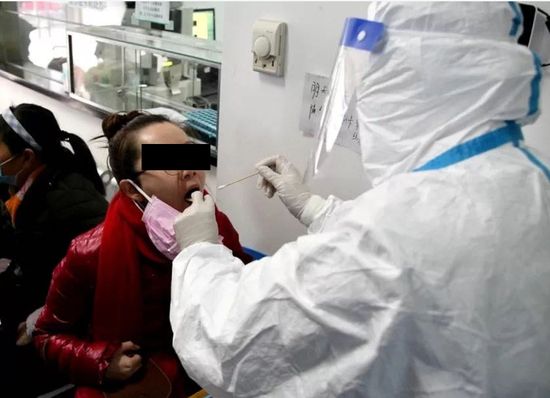 Nhân viên y tế tại Bệnh viện Hiệp Hòa, Vũ Hán dùng que gạc lấy mẫu dịch ở họng của bệnh nhân để xét nghiệm virus Corona mới (Ảnh: Guancha).