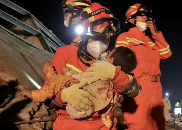 Một trẻ em bị vùi trong đống đổ nát được cứu thoát (Ảnh: Đông Phương).