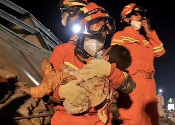 Một trẻ em bị vùi trong đống đổ nát được cứu thoát (Ảnh: Đông Phương).