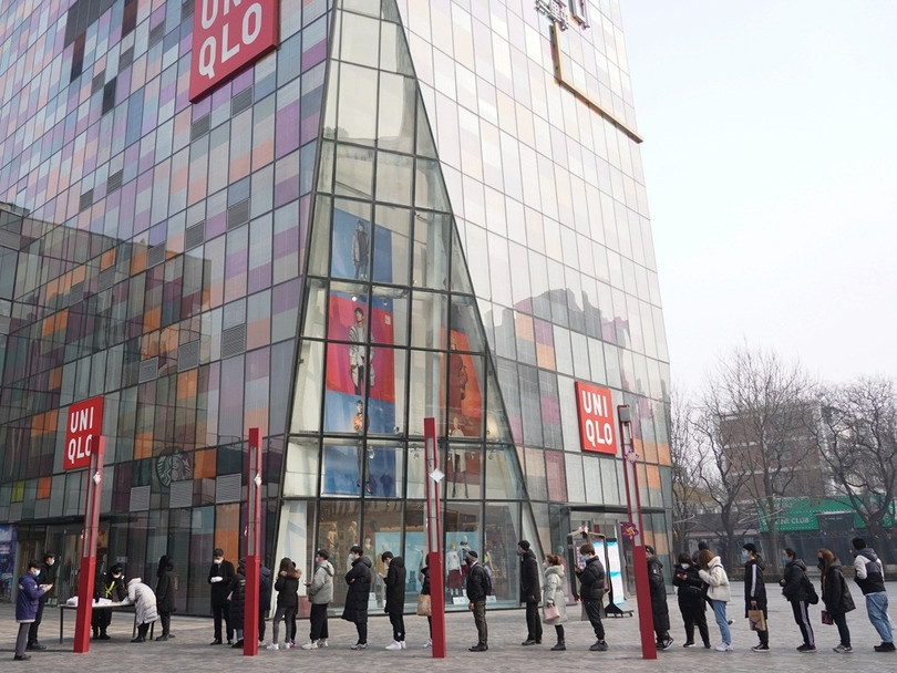 Các nhân viên một trung tâm thương mại ở Bắc Kinh xếp hàng chờ đo nhân nhiệt trước khi vào ca làm việc (Ảnh: Tân Hoa xã)