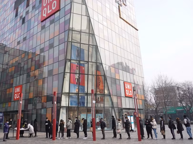 Các nhân viên một trung tâm thương mại ở Bắc Kinh xếp hàng chờ đo nhân nhiệt trước khi vào ca làm việc (Ảnh: Tân Hoa xã)